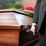 Pallbearer holding a wooden casket handle