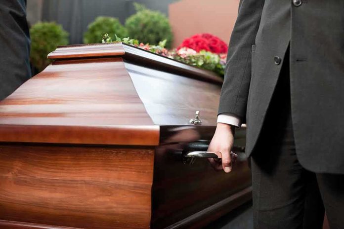 Pallbearer holding a wooden casket handle