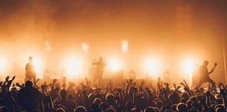 Rock Icon GONE — Mystery Lingers Rock band performing on stage with bright backlights and cheering crowd