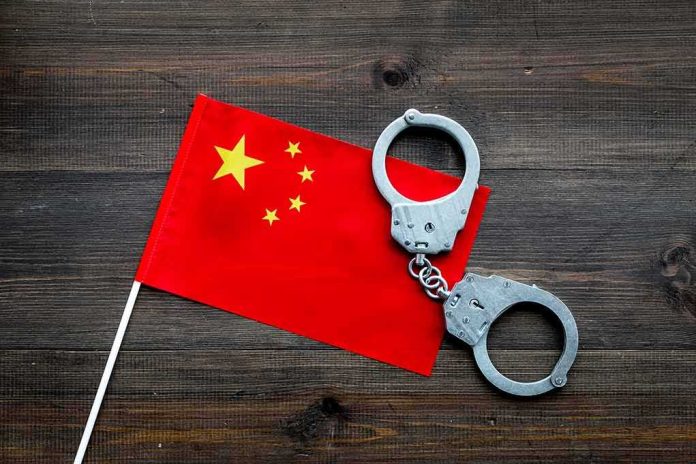Chinese flag with metal handcuffs on wooden table