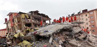 INDEPENDENCE DAY Turns Into HORROR Rescue workers in orange uniforms on a collapsed building site after an earthquake