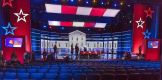 HIJACKED! — Election Night Narrative Spins Out Debate stage with red and blue lighting and empty audience seats