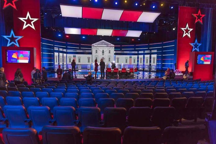 shutterstock_1656995731 Debate stage with red and blue lighting and empty audience seats