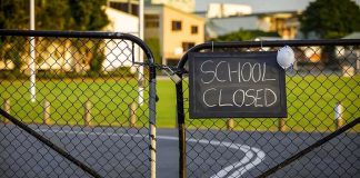 Bullying Bombshell — 2 STUDENTS DEAD Chain-link school gate with a sign reading school closed