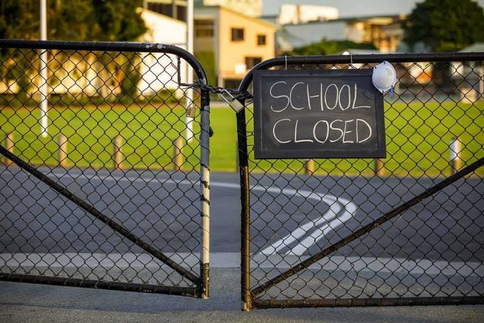 Chain-link school gate with a sign reading school closed