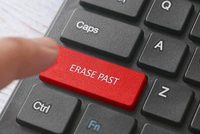shutterstock_1711581625 Finger pressing a red keyboard key labeled erase past