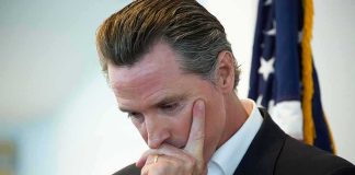 man in suit touching his face thoughtfully