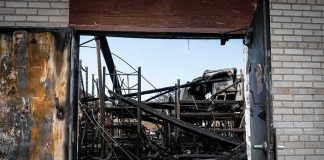 Books BURNED, Kids BLINDSIDED burned warehouse interior seen through open doorway