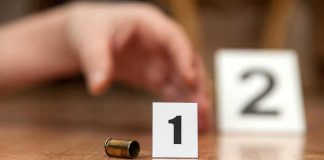 TWO Bodies, One Day — CITY on Edge Bullet casing beside evidence marker 1 on floor