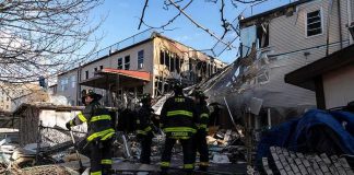 Firefighters assess damage at a collapsed residential building