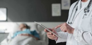 HORROR at the Hospital — Organs Taken BEFORE DEATH! Doctor using tablet beside hospital patient