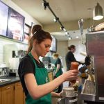 Barista preparing a drink at a coffee shop counter