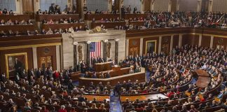 Stunner At Hearing — NEW SPY BOSS Sidesteps! Legislative chamber filled with attendees during a formal address