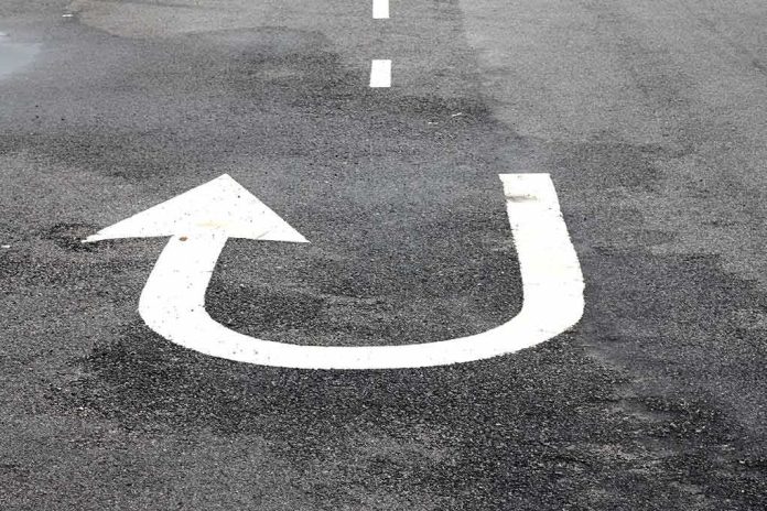 shutterstock_528097312 U-turn arrow painted on asphalt road