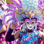 Dancer in ornate purple carnival mask and headdress