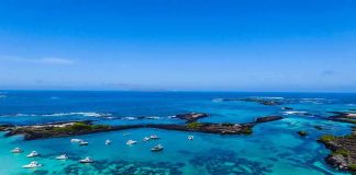 Boats anchored in turquoise lagoon with rocky islets