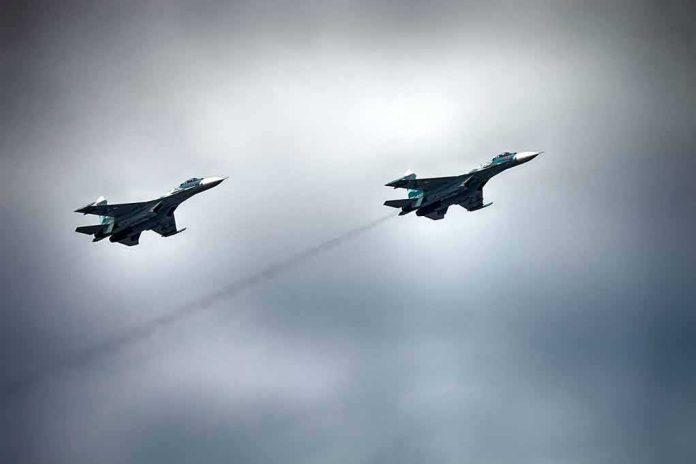 Two military fighter jets flying in formation under cloudy sky