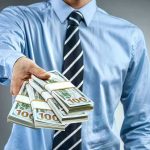 PARDONS Have A Price Tag — The Question Nobody On TV Asked Person in business attire offering bundles of US dollar bills