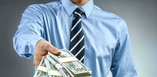 PARDONS Have A Price Tag — The Question Nobody On TV Asked Person in business attire offering bundles of US dollar bills