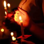 Trump Left The Stage To Hold Her — Then She Walked Into COURT Hands holding lit candles in a dark setting