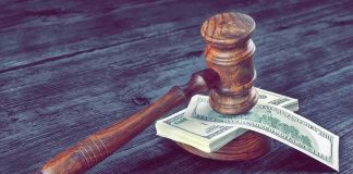 HIDDEN Six-Figure Judgment Bites CANDIDATE Judge's gavel resting on a stack of US dollar bills
