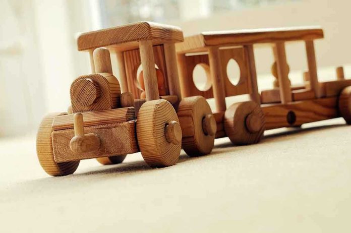 A wooden toy train set on a carpeted surface
