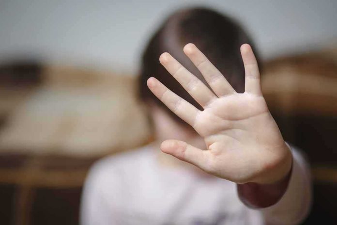 child raising hand to the camera