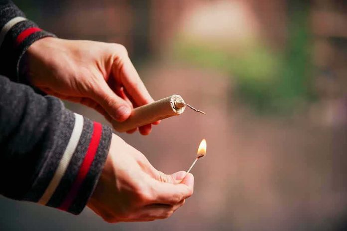 shutterstock_1057569650 Hands lighting a firework fuse with a match