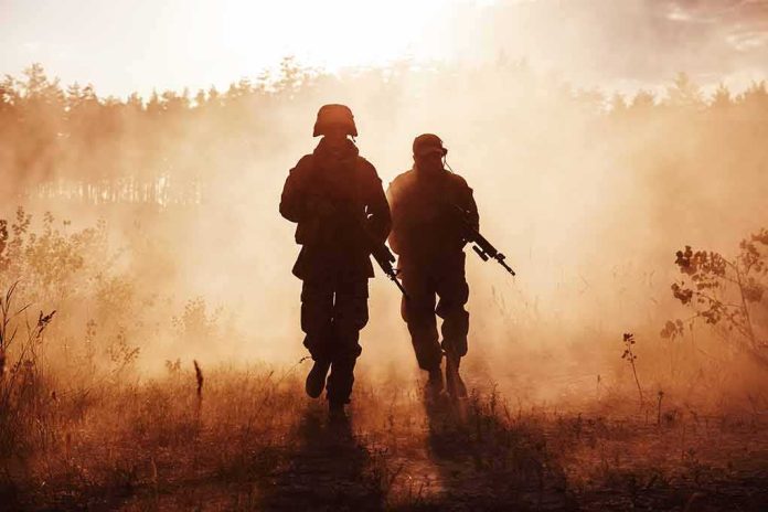 Two soldiers walking through a smoky field at sunset