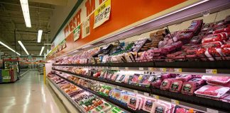 Grocery store meat aisle stocked with packaged beef and poultry