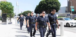Police officers walking in formation on a city sidewalk