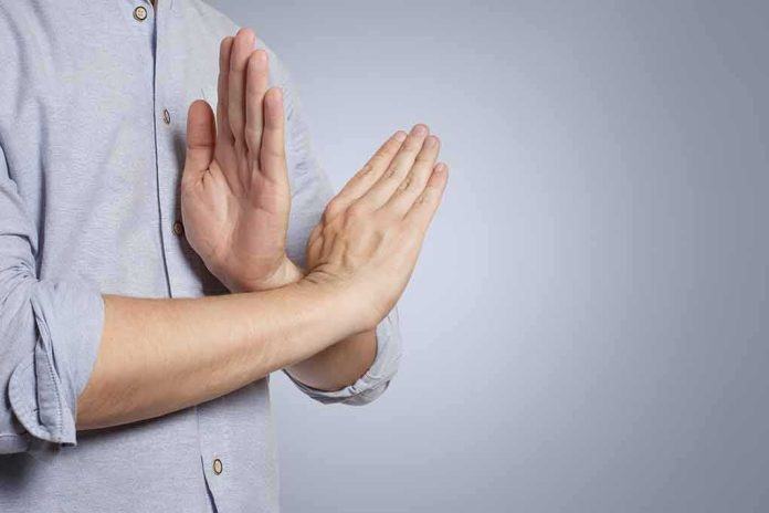 Person's hands making a stop gesture