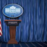 White House Prayer Fest SPARKS Uproar! White House press briefing podium with U.S. flag and blue curtain
