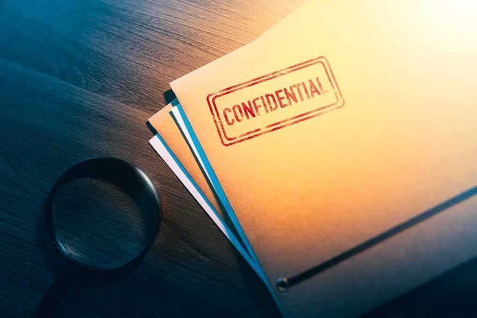 shutterstock_1188557536 Confidential folder on desk with magnifying glass