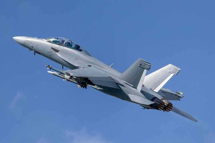 Twin-engine fighter jet climbing in a clear blue sky