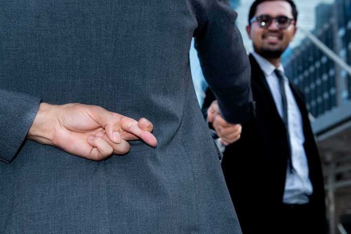 Businessman crosses fingers behind back during handshake