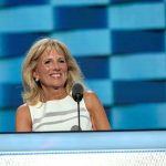 Jill Biden speaking at a podium with a blue backdrop