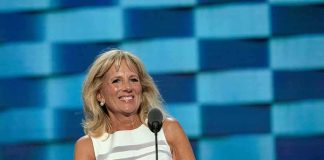Jill Biden speaking at a podium with a blue backdrop