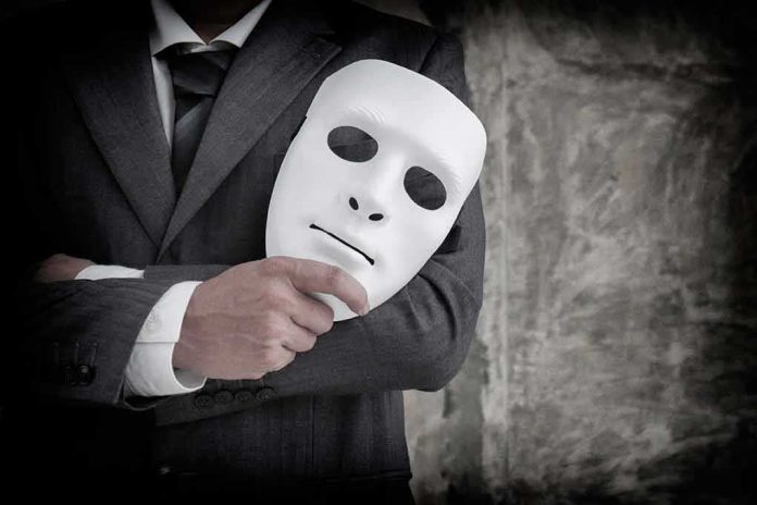shutterstock_1453737242-1 person in suit holding a white expressionless mask