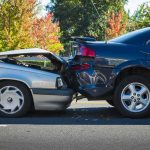 Two cars in a rear-end collision on a city street