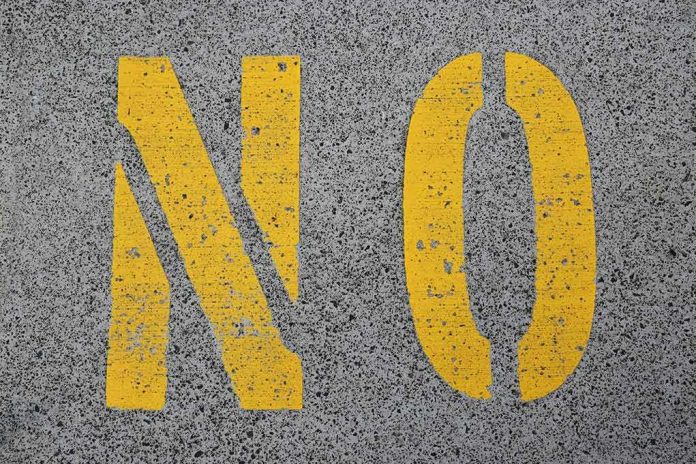 Yellow letters NO painted on gray asphalt