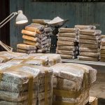 Stacks of wrapped packages on tables in a dim room