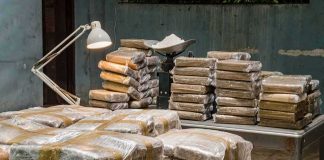 Stacks of wrapped packages on tables in a dim room