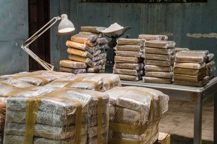 shutterstock_1674487648 Stacks of wrapped packages on tables in a dim room