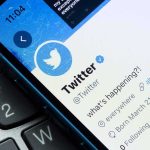 Smartphone showing Twitter profile page on a laptop keyboard