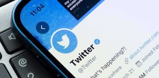 Smartphone showing Twitter profile page on a laptop keyboard