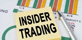Sticky note reading INSIDER TRADING on financial charts with a pen