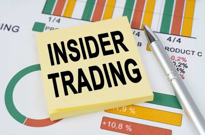 Sticky note reading INSIDER TRADING on financial charts with a pen