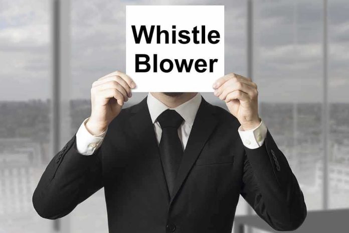 shutterstock_225889915 Person in suit holding a sign in front of their face