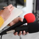 St. Louis PD Lost DAYS Chasing Monkeys Journalist holding two microphones while writing in a notebook